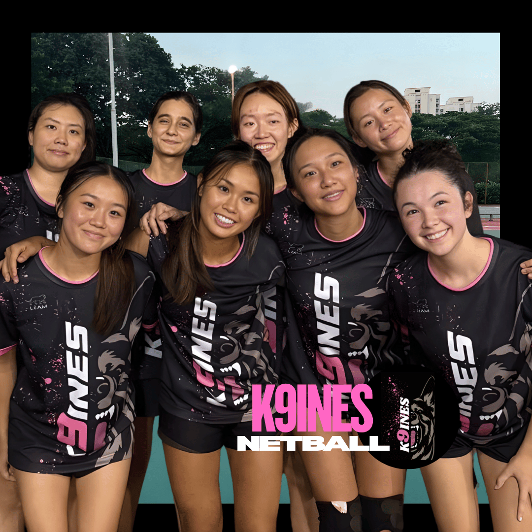 A group of seven female netball players posing together, wearing custom made netball jerseys. 